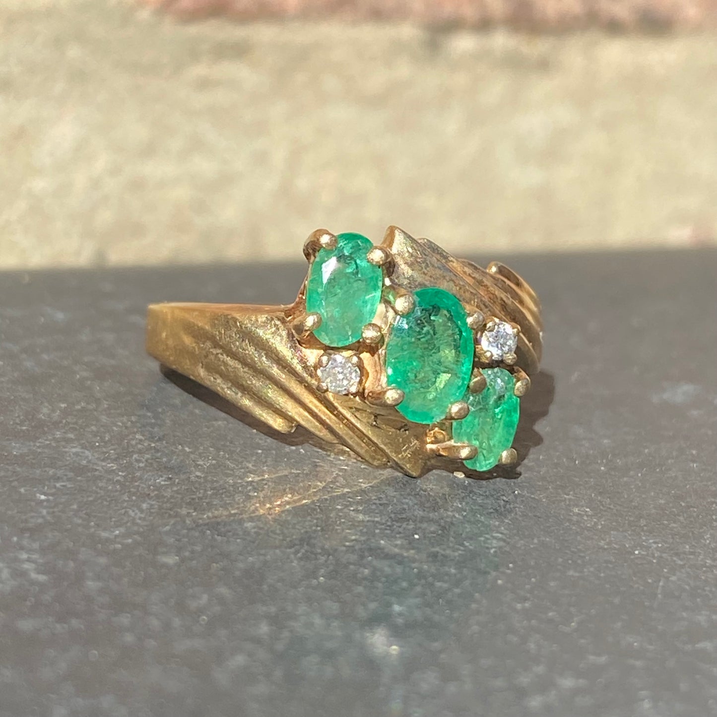 Emerald three stone ring with accent diamonds