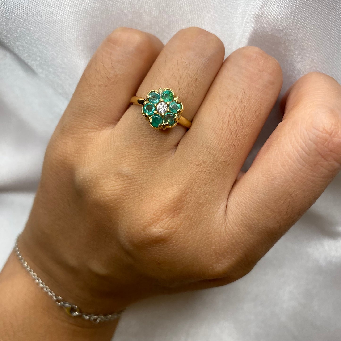 Emerald cluster ring with diamond center