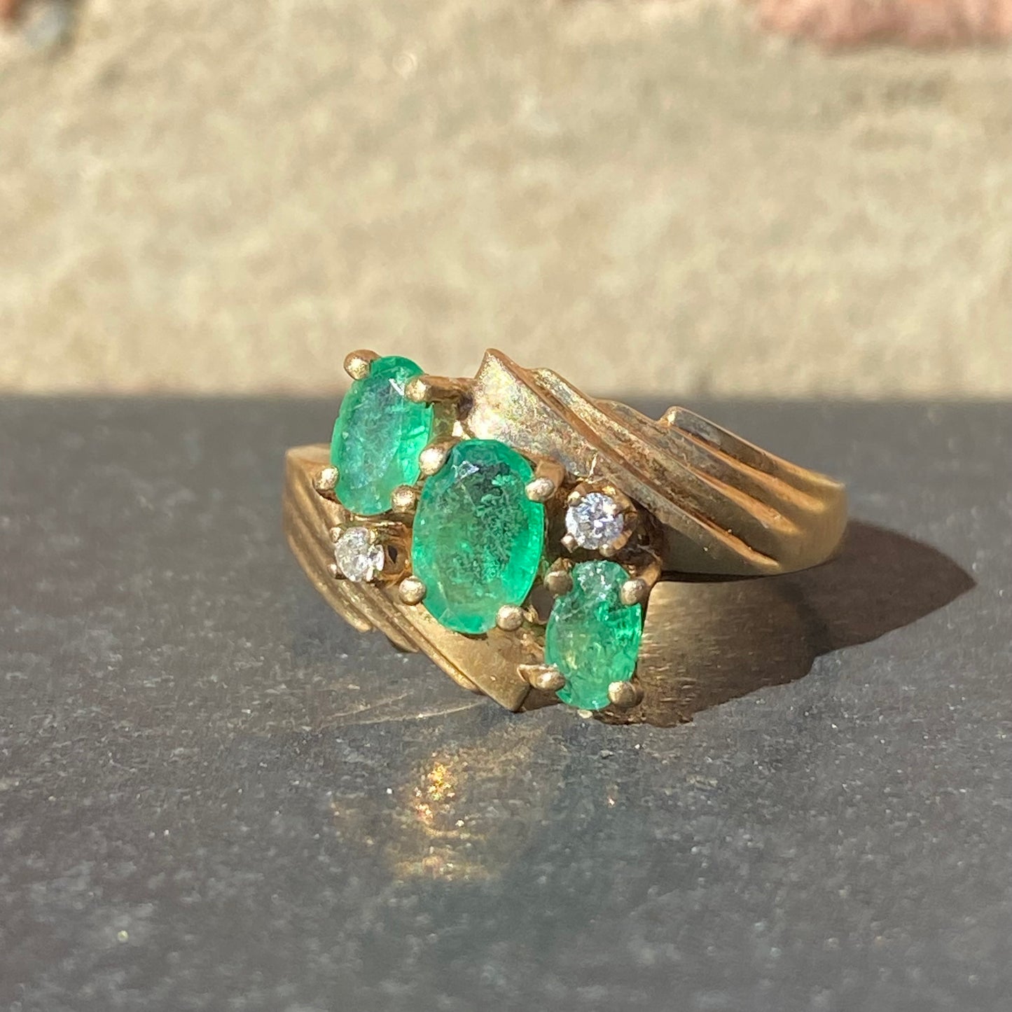 Emerald three stone ring with accent diamonds