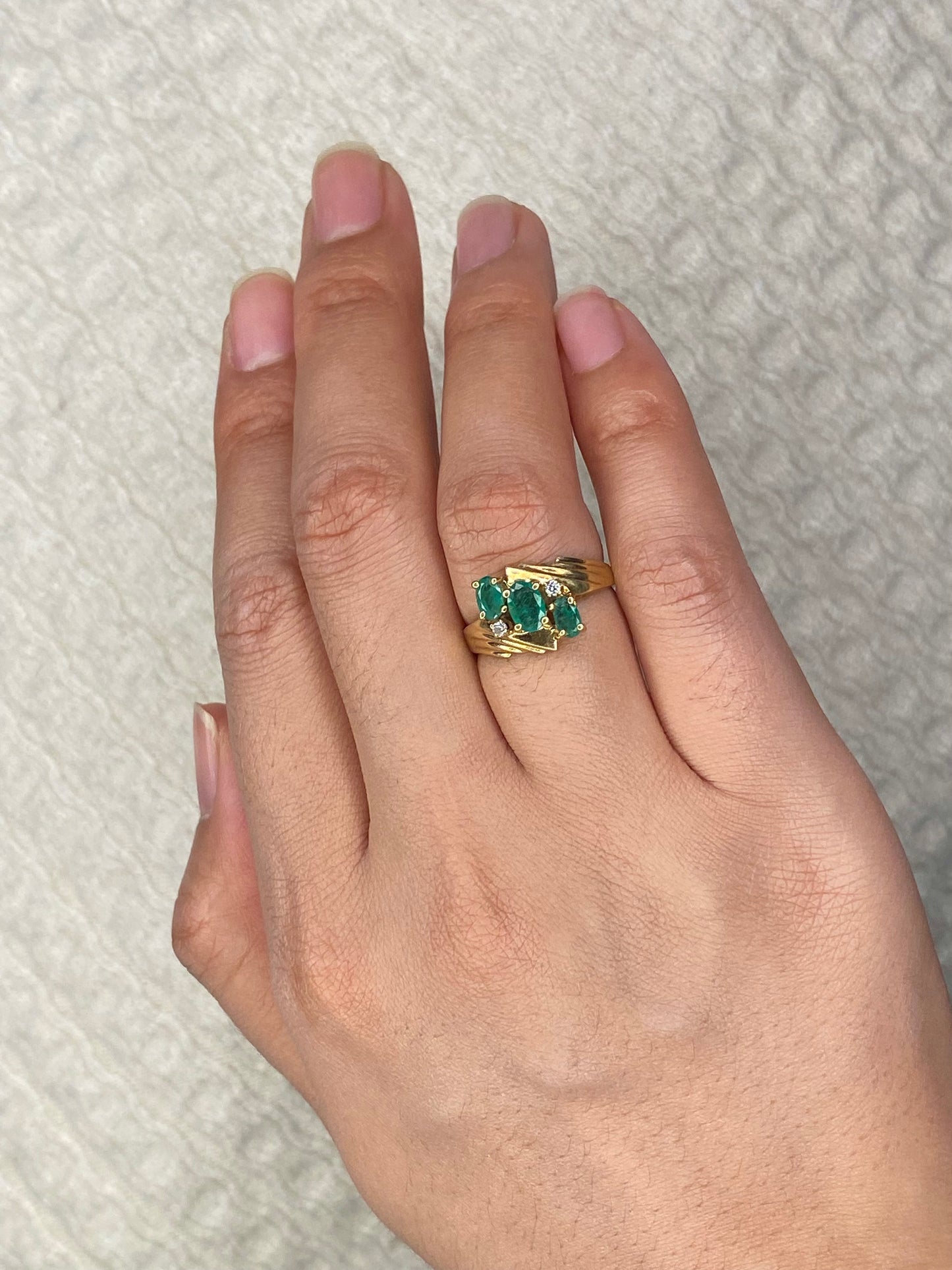 Emerald three stone ring with accent diamonds