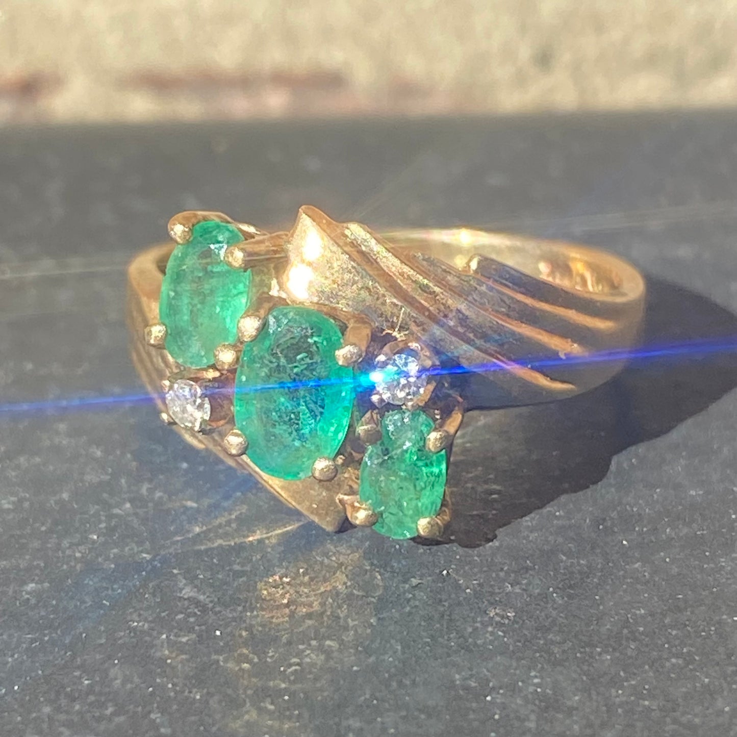 Emerald three stone ring with accent diamonds